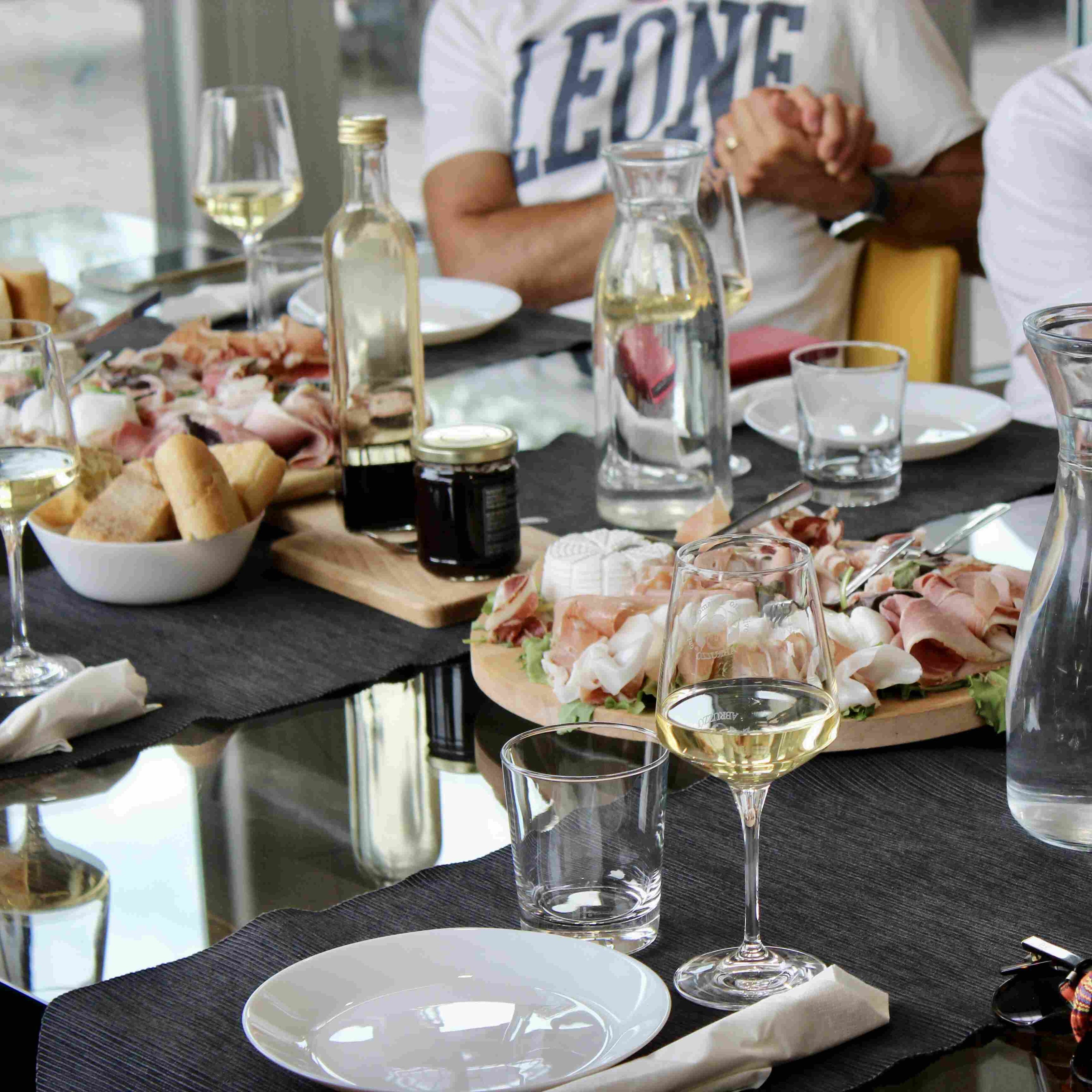 Degustazione di vini Abruzzo con tavolo imbandito di salumi locali, pane e formaggi, presso Cantina Margiotta